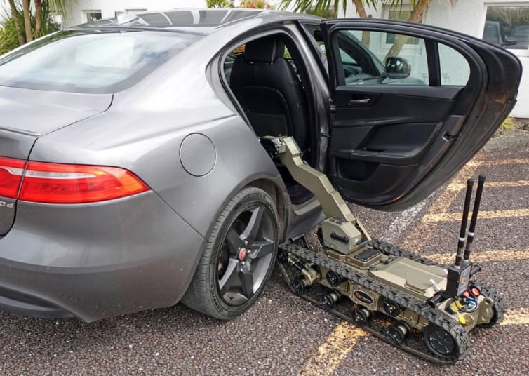 Avenger LT UGV positioned beside an open vehicle door