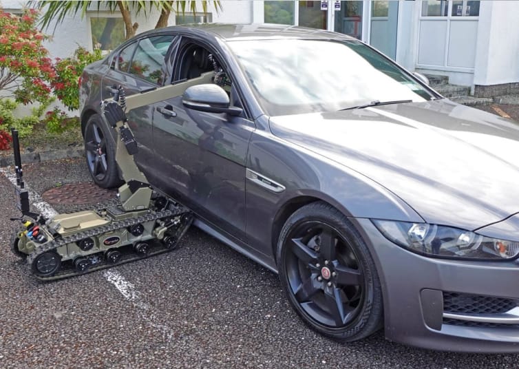 UGV robotic arm reaching through a vehicle window