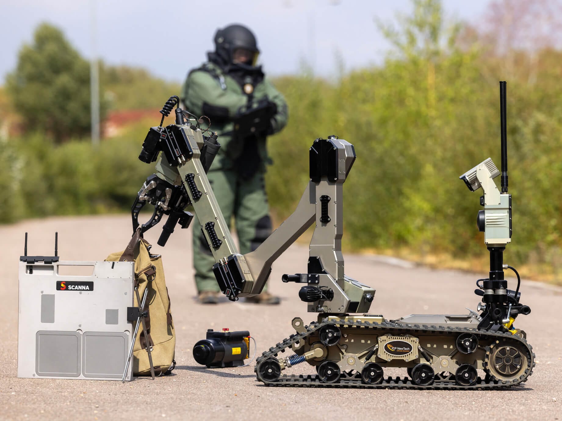 Avenger 2.0 inspects a suspicious bag with a bomb disposal operator in the background