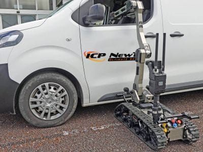 ICP NewTech Avenger UGV positioned beside a vehicle reaching in through the window